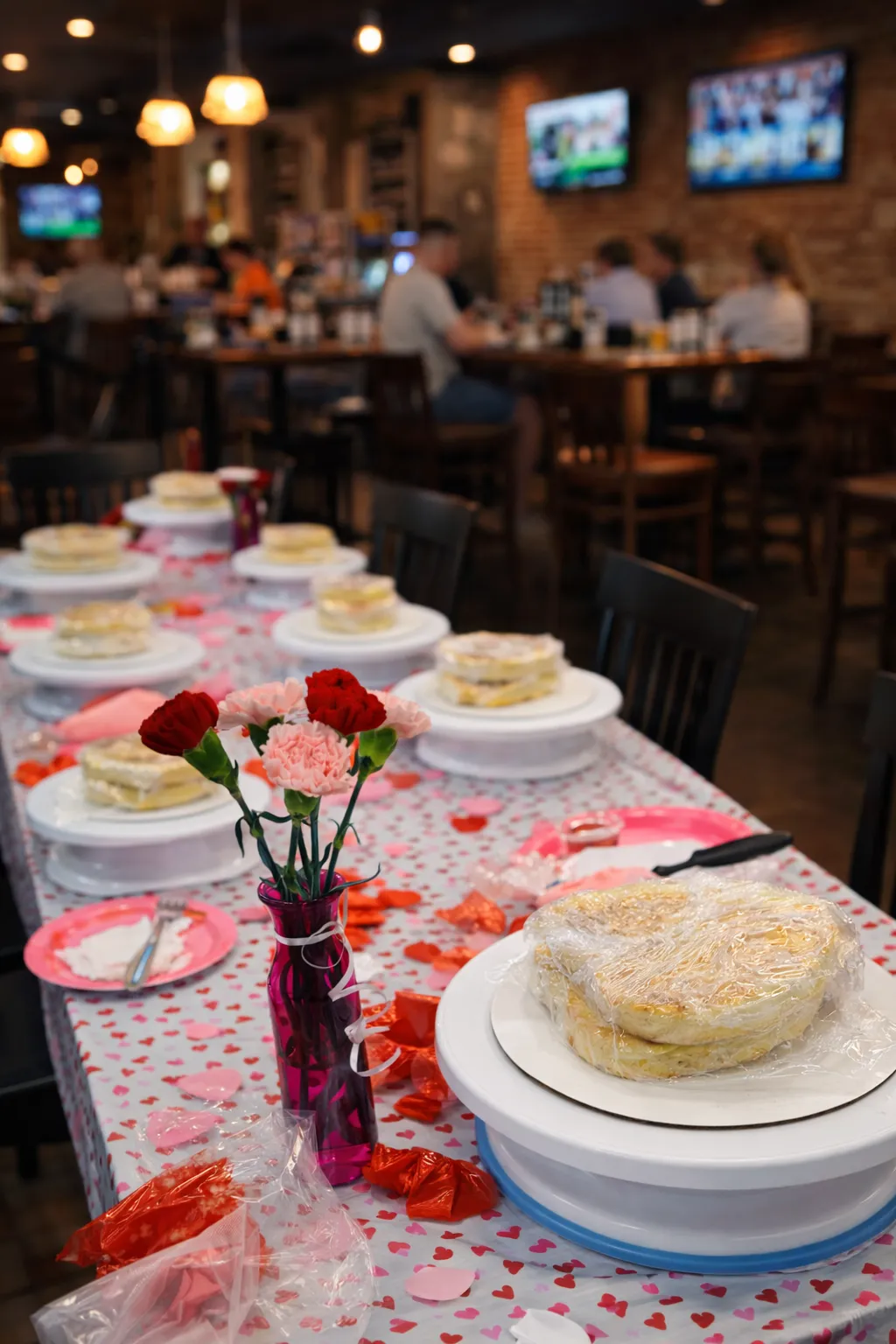 Friends raising glasses around a table of partially decorated cakes