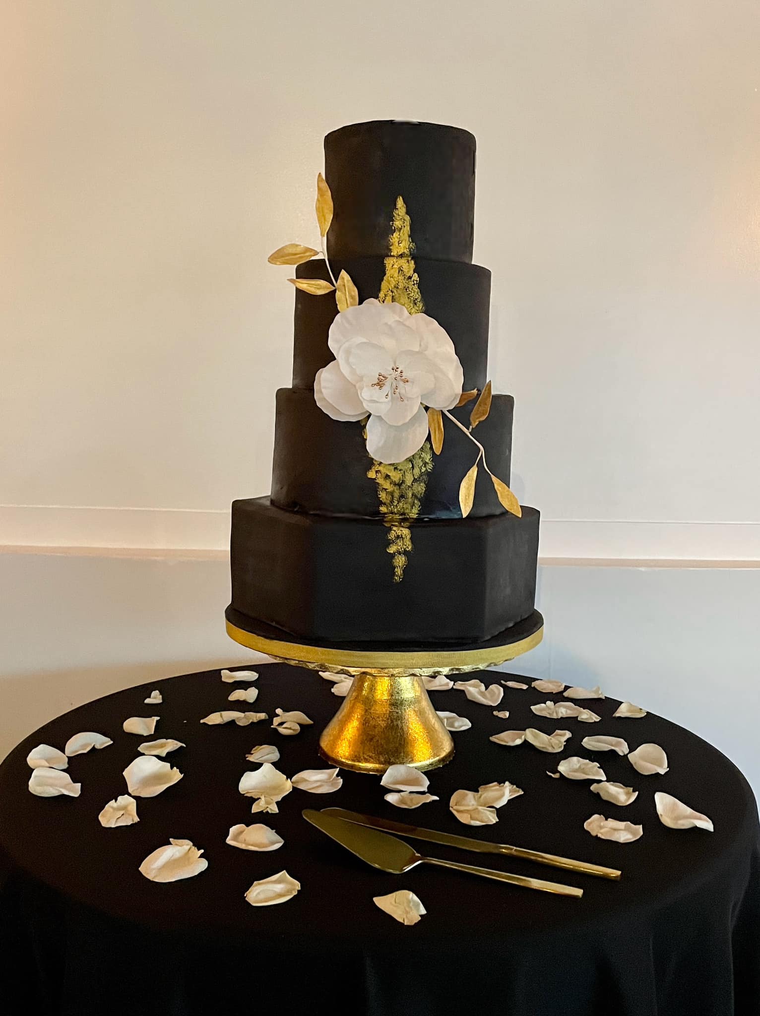 Cake artist smoothing frosting on a tiered cake in a studio