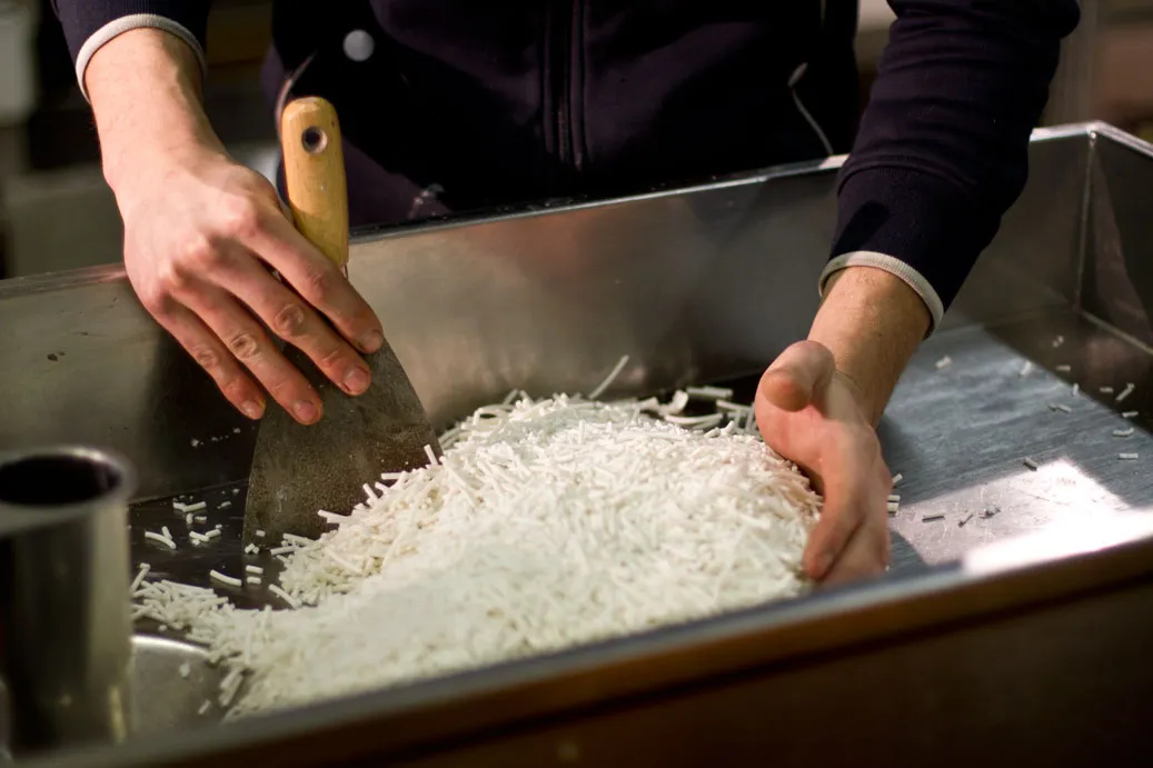 Handmatige verwerking van plantaardige zeepbasis tijdens het vervaardigen van gepersonaliseerde zeepjes in ons atelier.