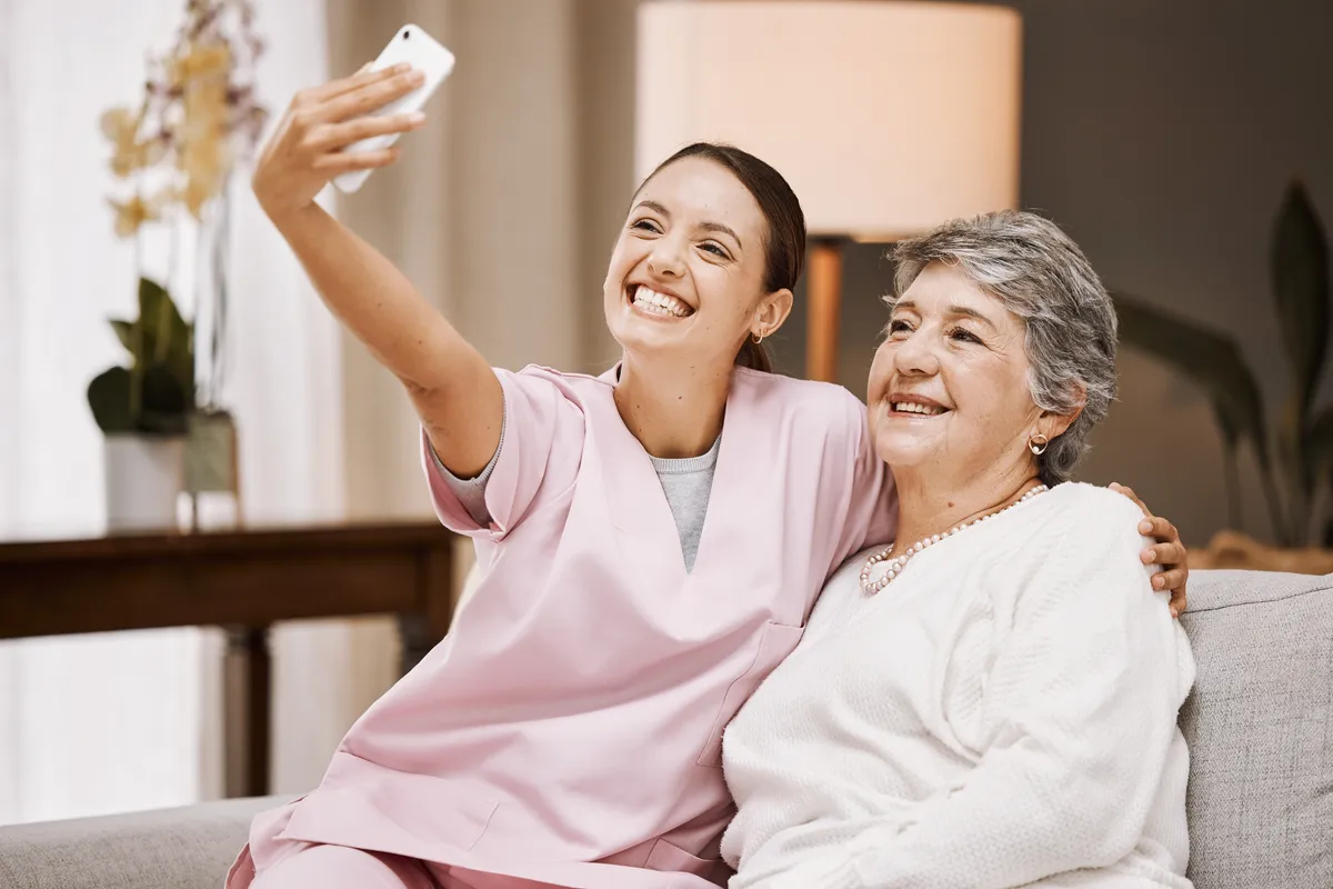 A People First Healthcare team member greeting an older woman at a community centre