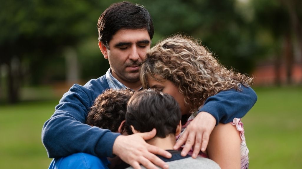 Parents embracing their children representing family financial protection