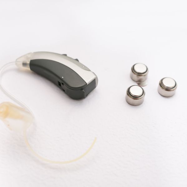 a hearing aid and three batteries