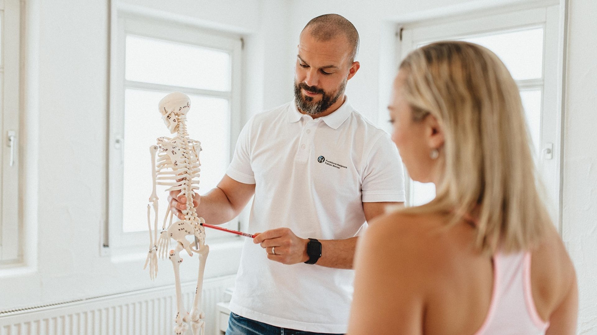 Fabian Berner erklärt einem Patienten das Erklärungsmodell seiner Beschwerden