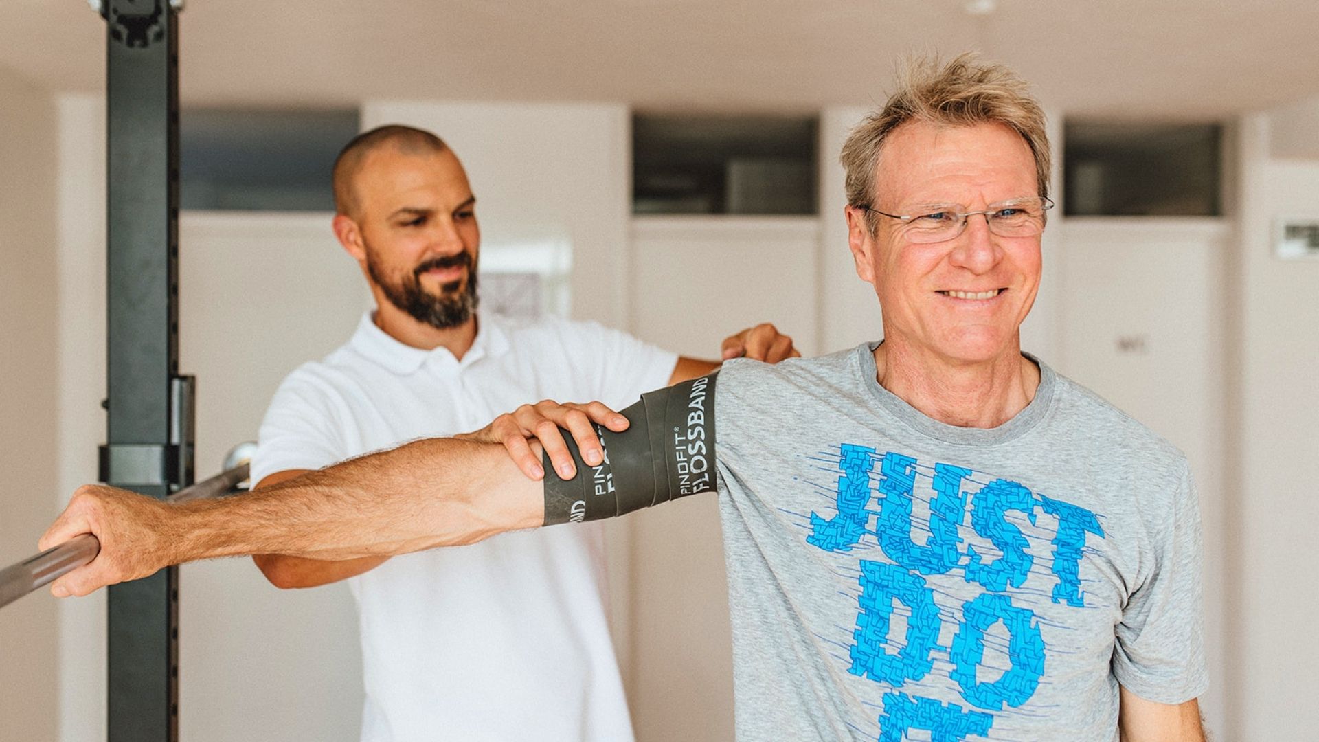 Fabian Berner hilft einem Patienten bei Schulterschmerzen.