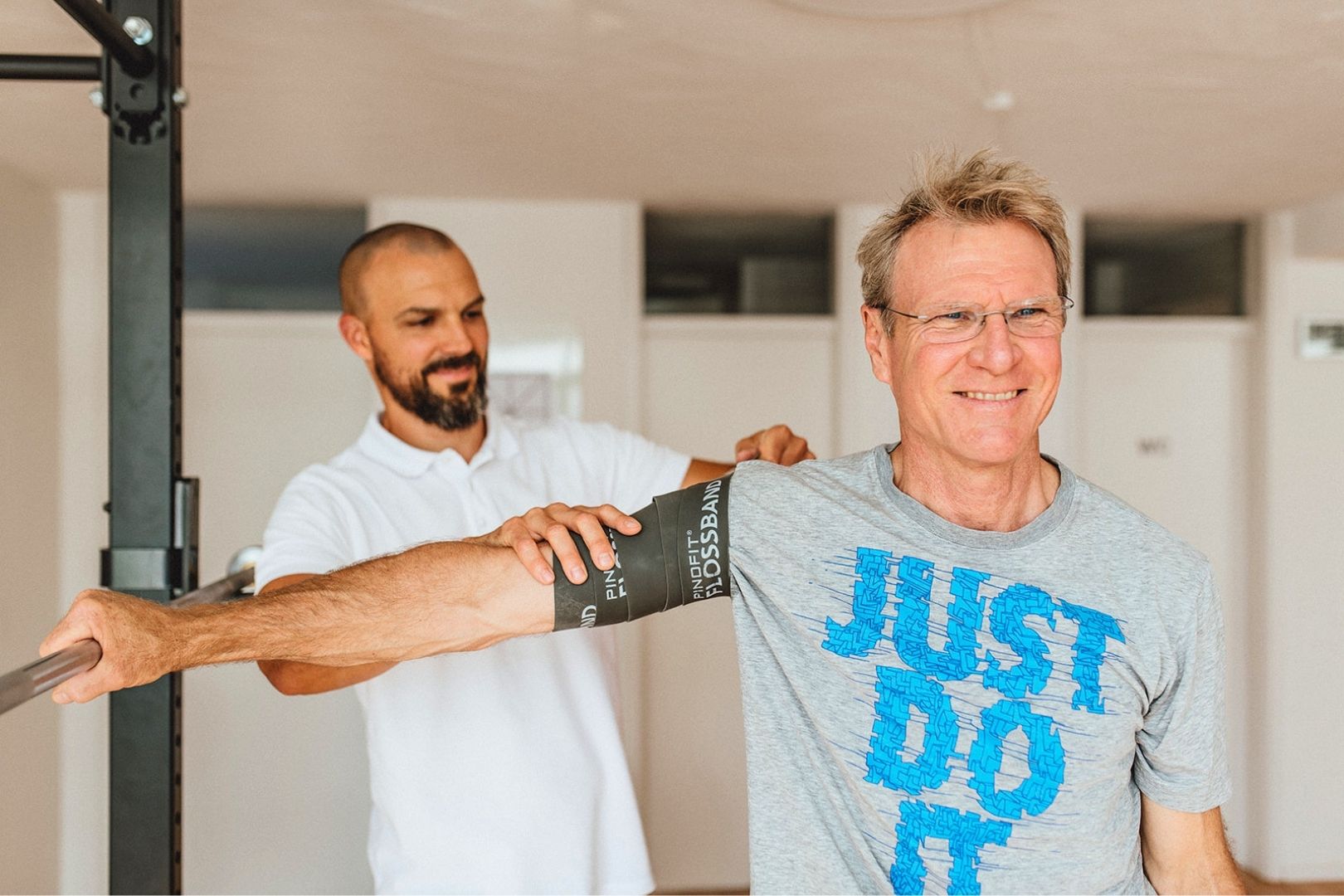 Fabian Berner hilft einem Patienten bei Schulterschmerzen.