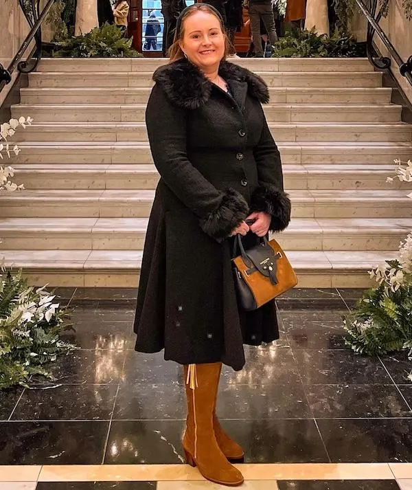 Corinna standing in the lobby of The Savoy in her tall boots