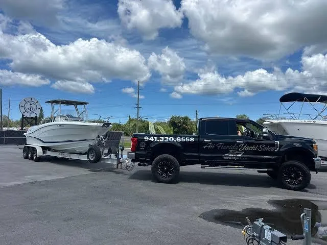 All Florida Yacht Sales truck towing boat on trailer at Ruskin Florida consignment lot — AFYS boat pickup and consignment service Tampa Bay