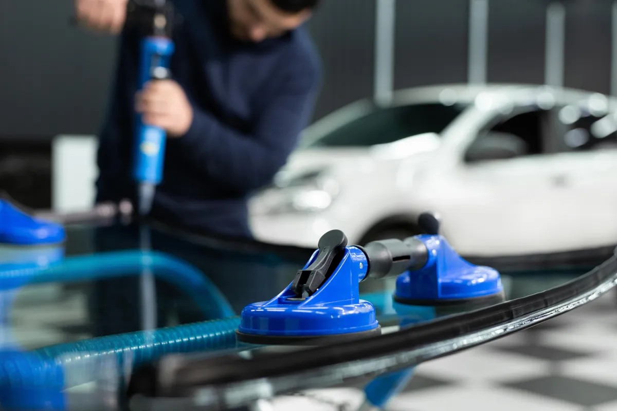 Auto Glass Technician Repairing a Windshield in a garage