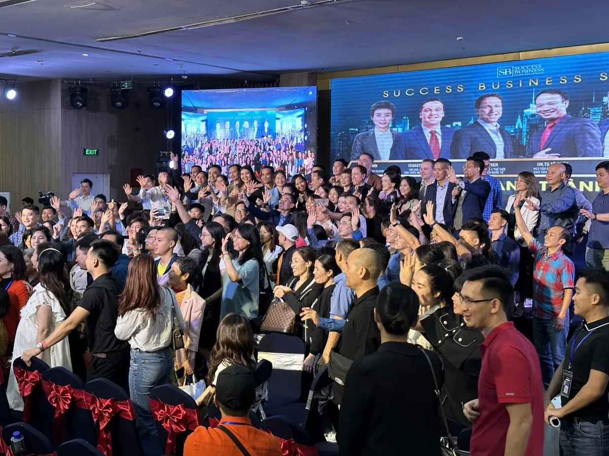 Attendees on their feet engaging with the Success Business Summit 2023 in Vietnam
