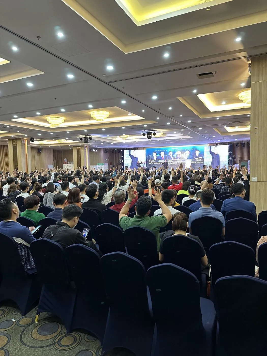 Packed ballroom audience raising their hands for Alasdair Cunningham at the Success Business Summit, Vietnam