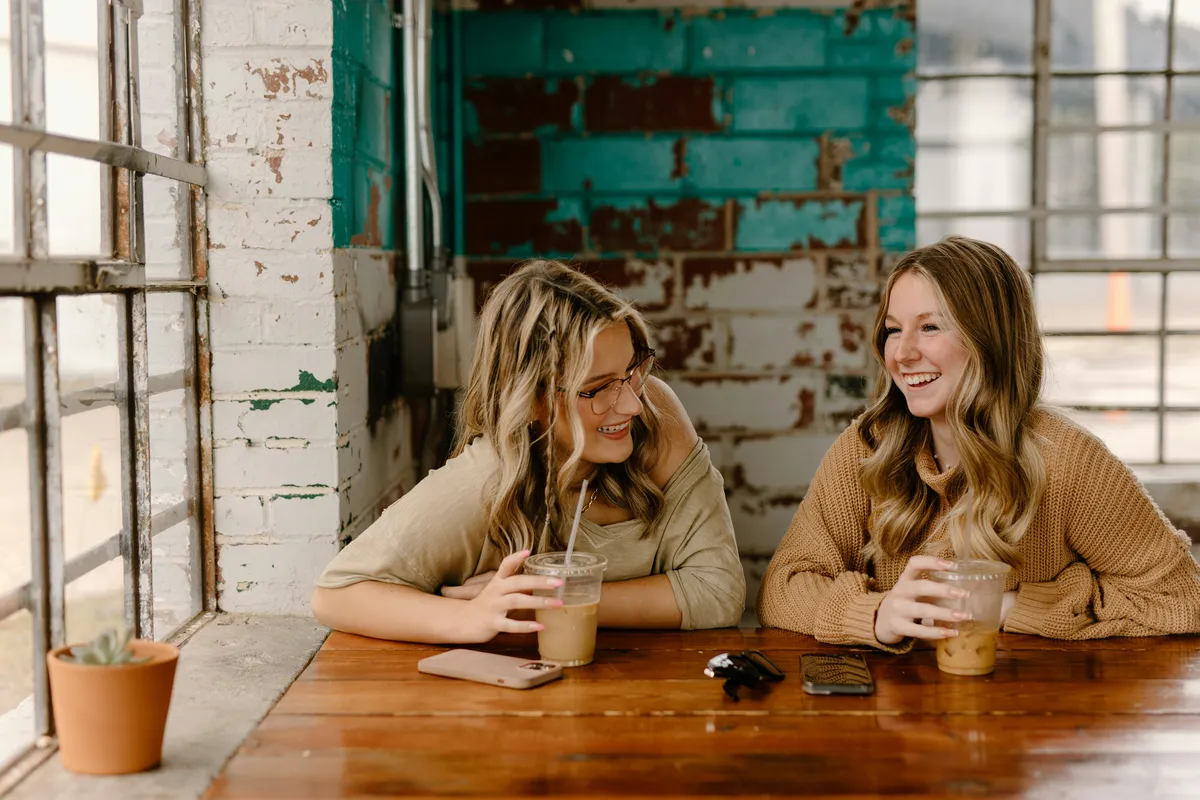 Two friends talking over coffee, the kind of conversation that leads to referrals