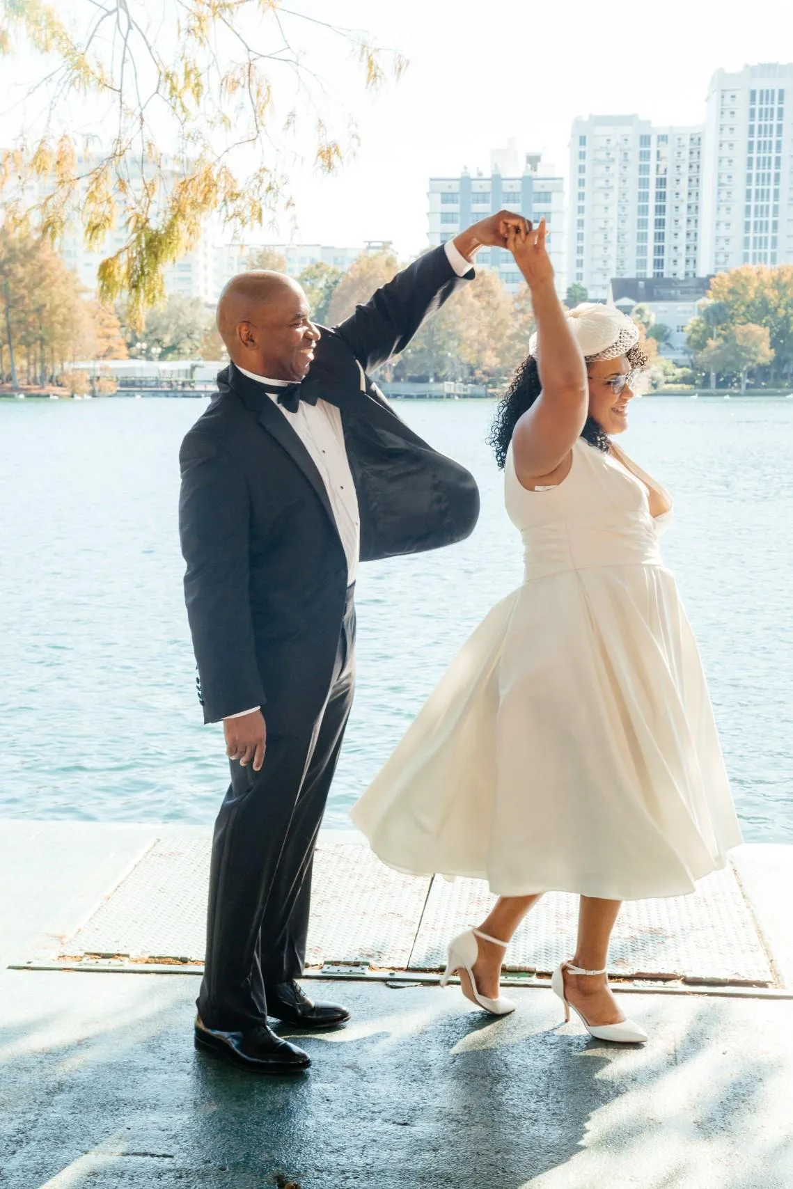 Groom twirls bride by Lake Eola, Orlando