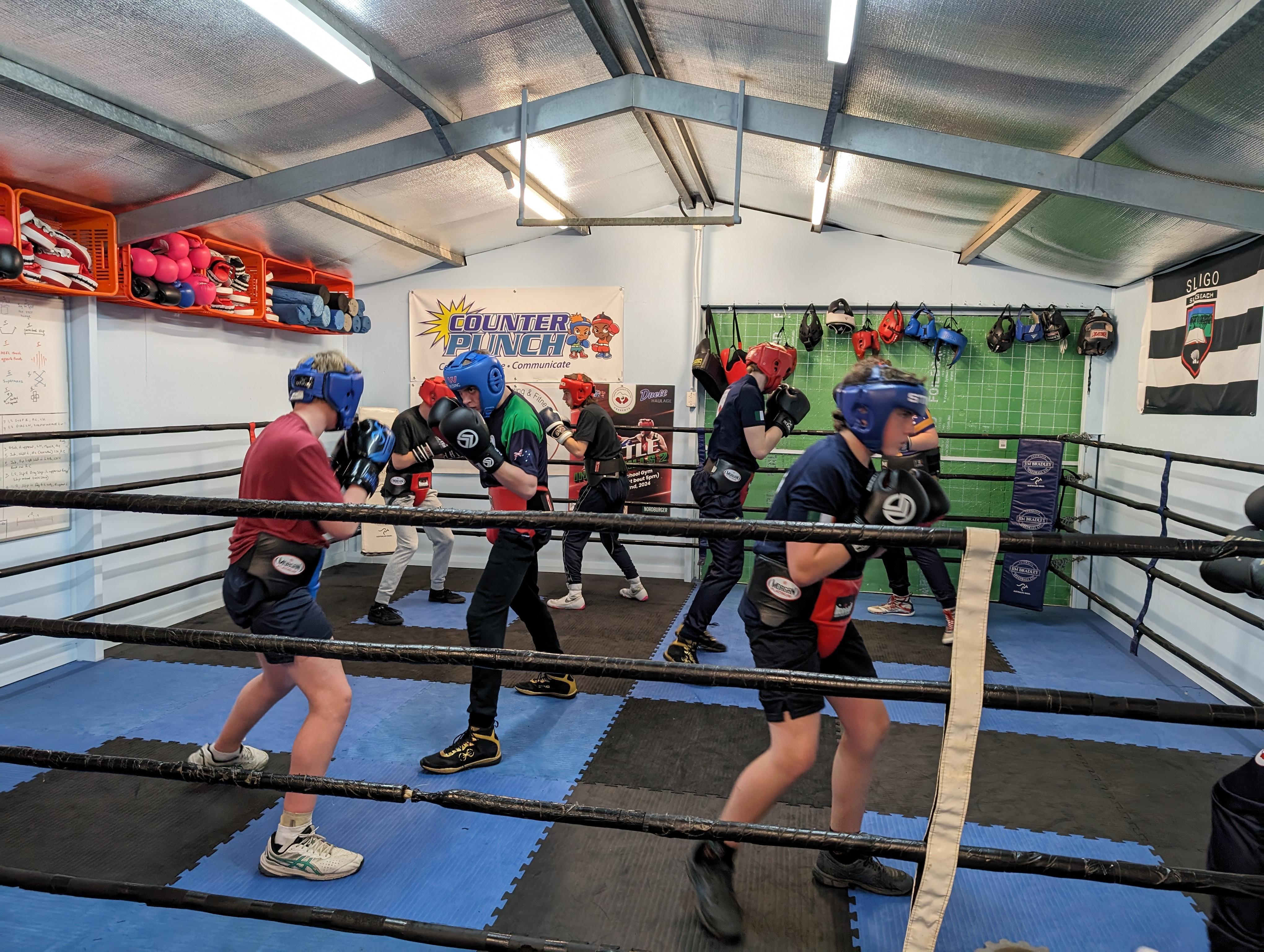 A coach running a group boxing session with teenagers at the CounterPunch gym