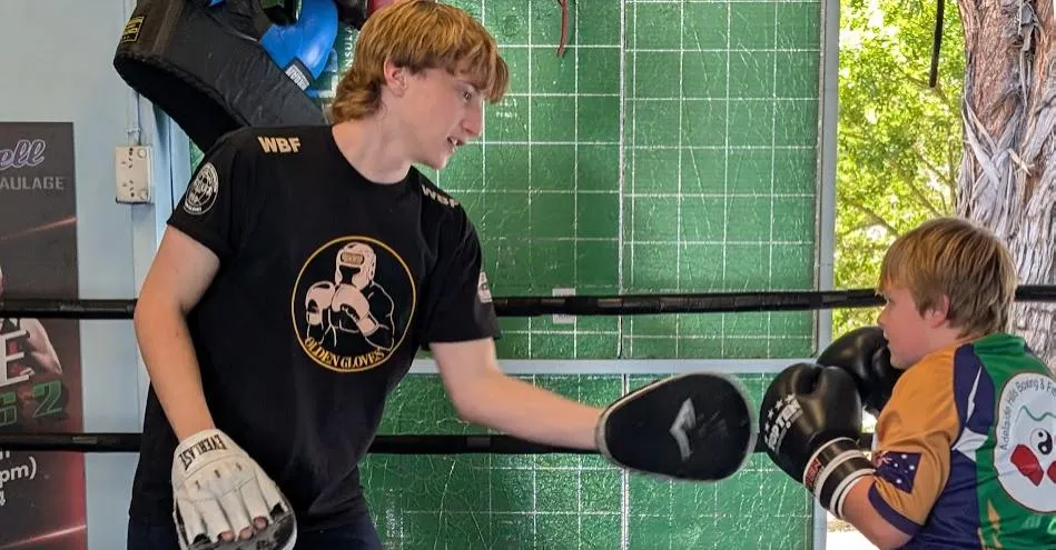 A CounterPunch facilitator coaching a teenager on boxing pads