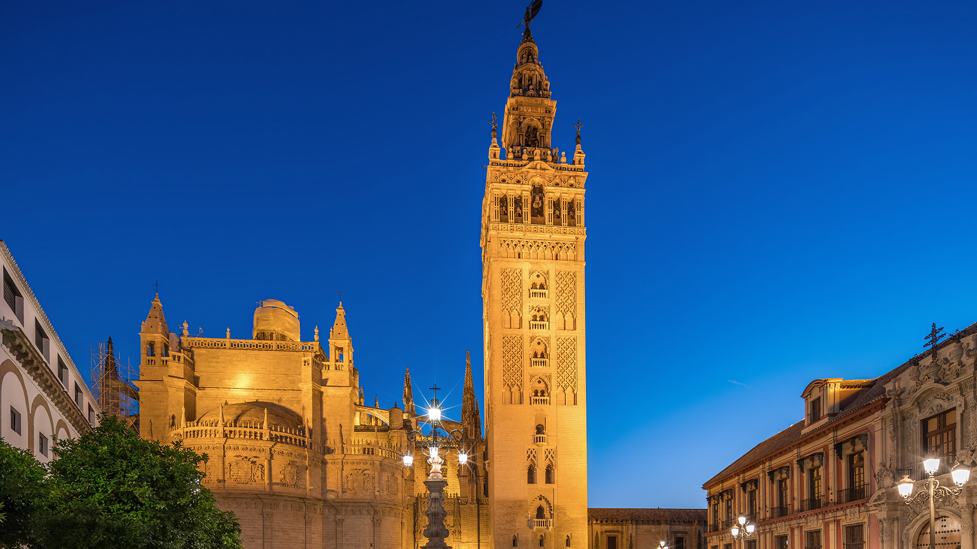 La Giralda and Seville Cathedral lit against the evening sky
