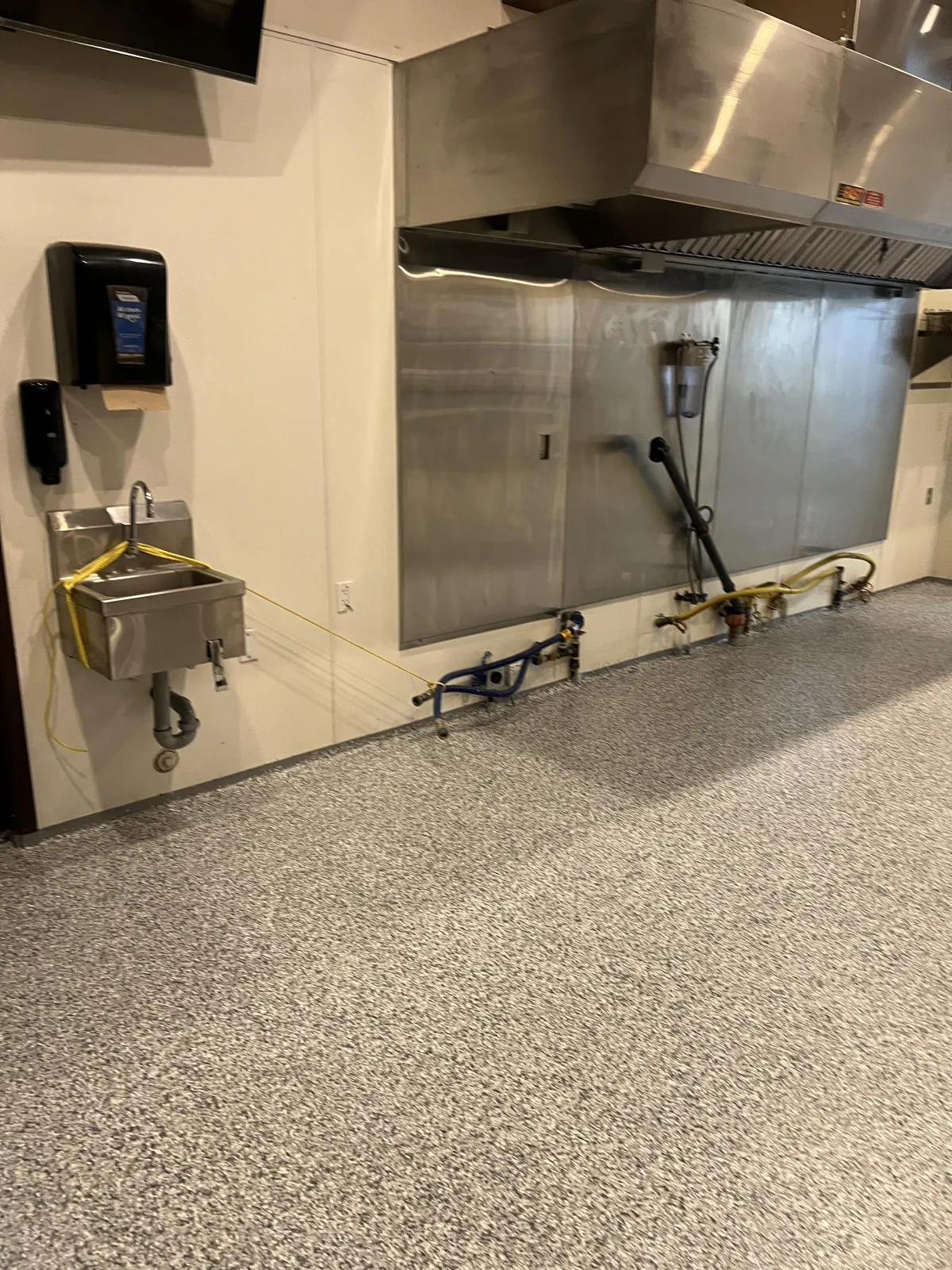 Commercial kitchen service area featuring durable light grey epoxy flake flooring