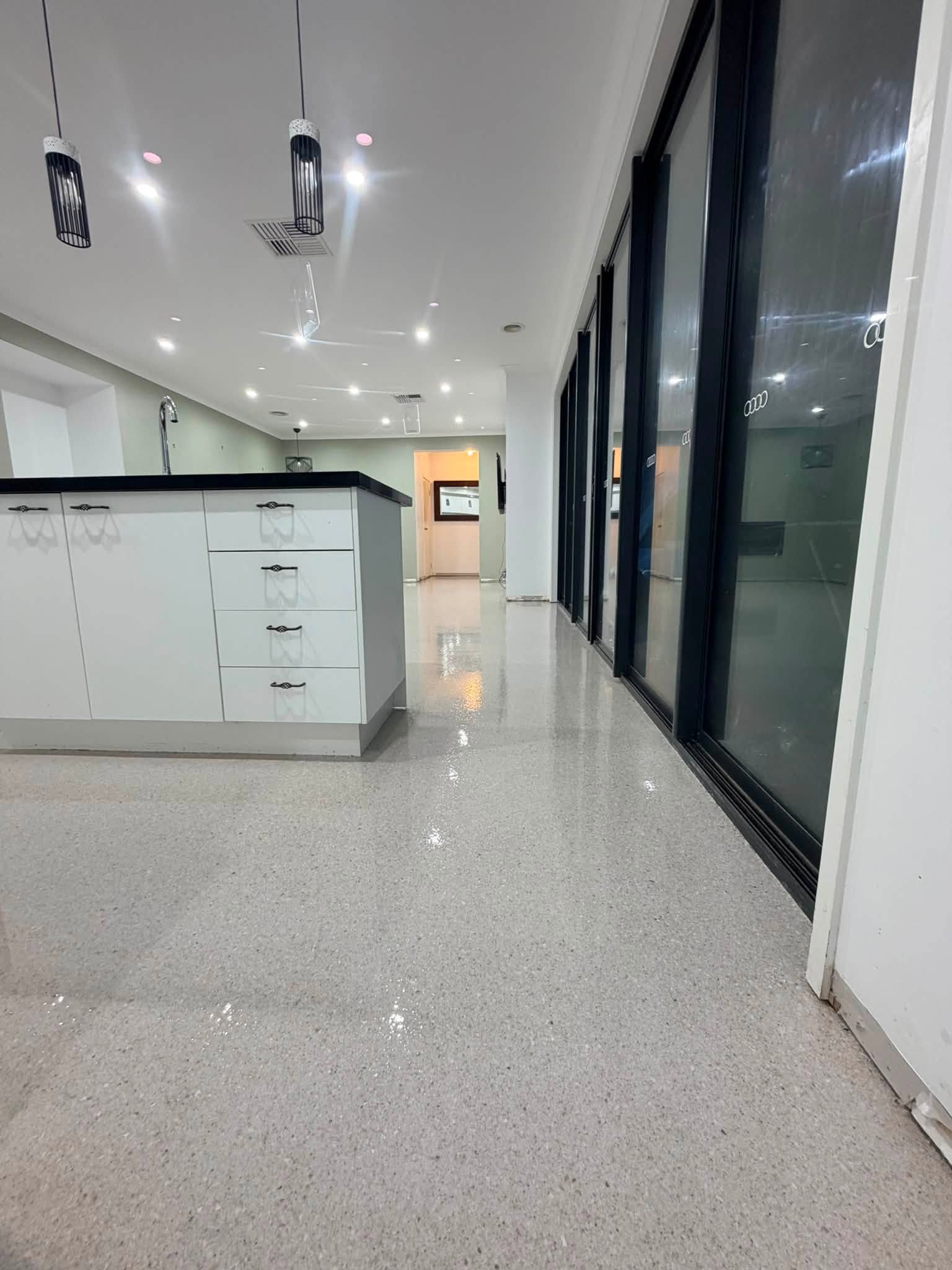 Modern interior kitchen space featuring clean white seamless epoxy floor coating