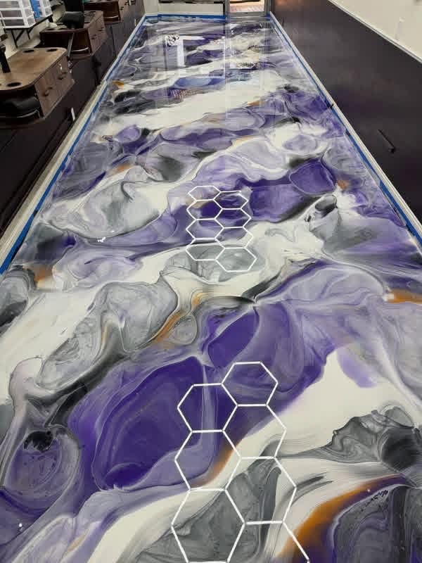 Custom table surface finished with vibrant purple and white metallic epoxy coating