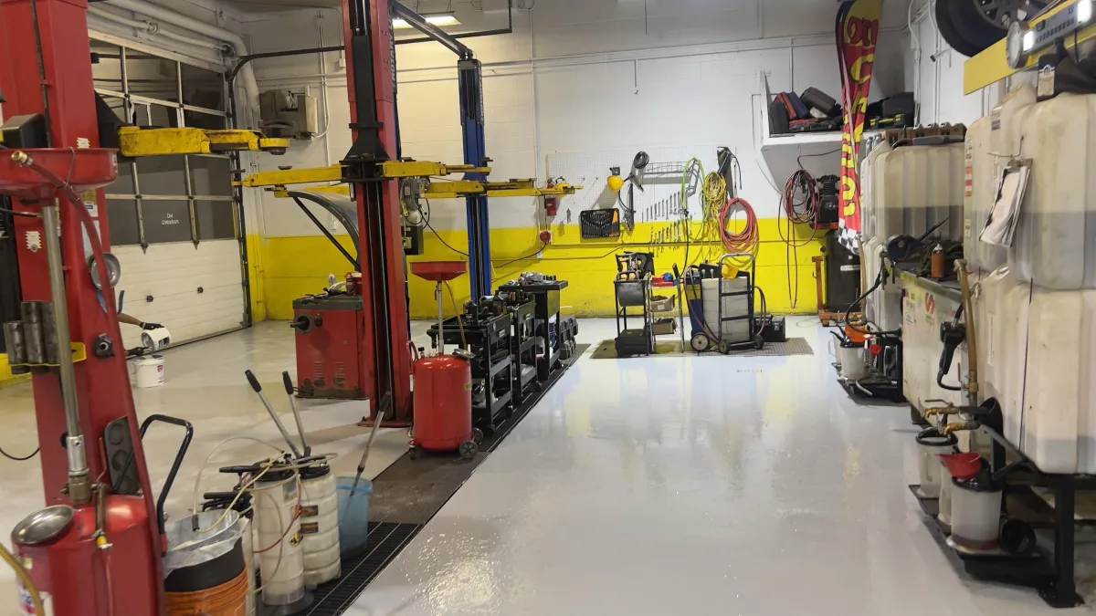 Auto repair shop bay with durable seamless white solid epoxy floor coating