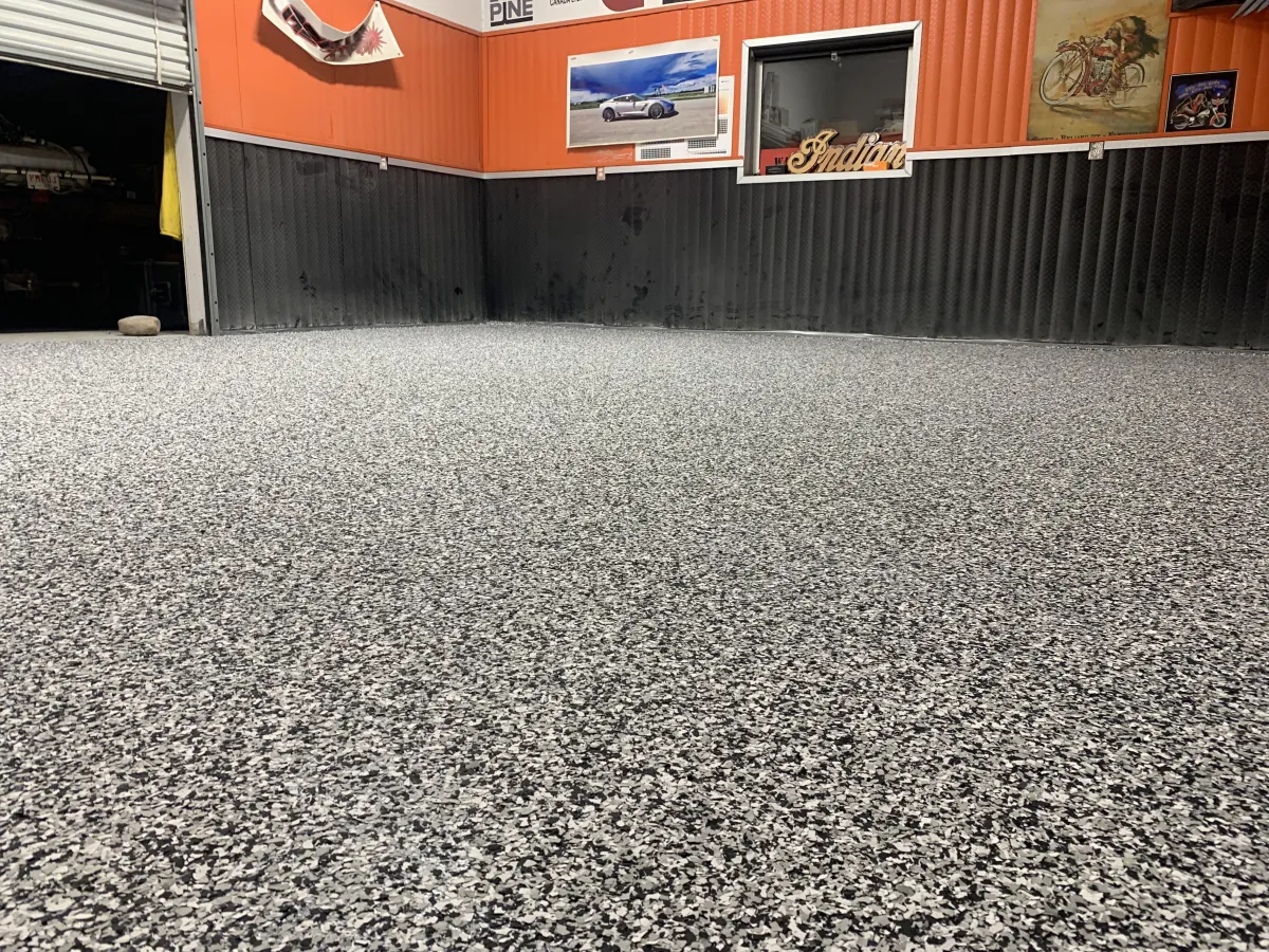 Commercial garage space with full-chip black and white epoxy flake flooring