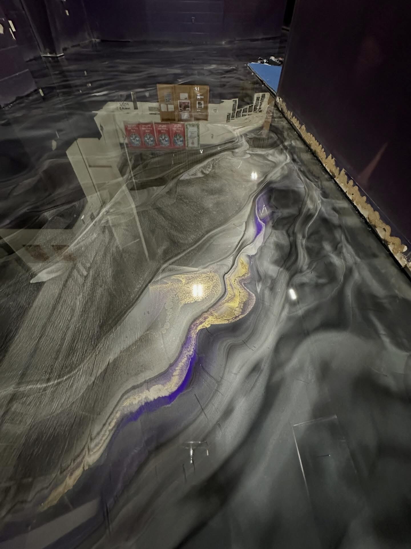 Close up of high-gloss metallic epoxy floor coating with grey and purple swirl pattern