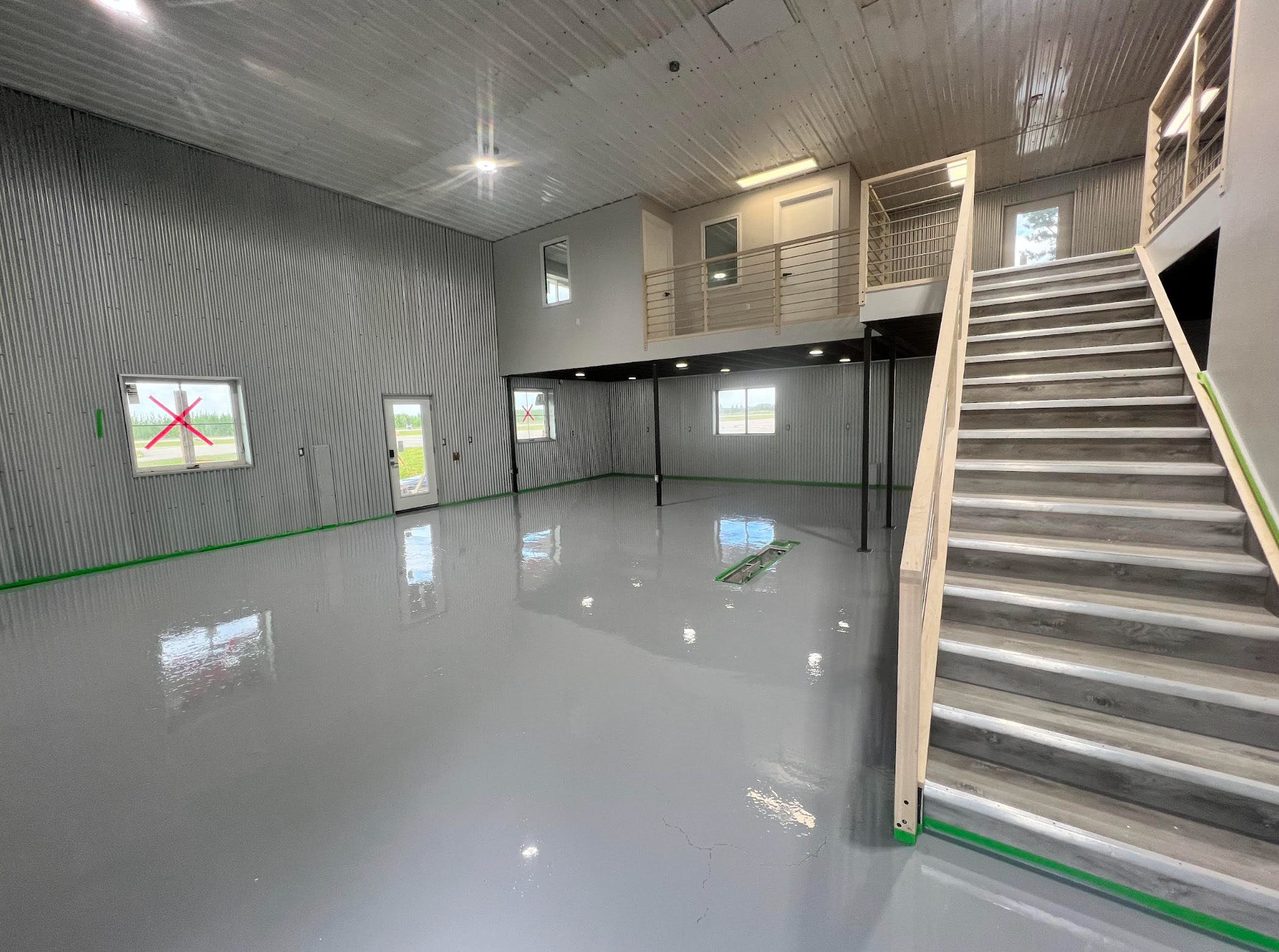 Spacious commercial warehouse with high-gloss light grey epoxy flooring and internal staircase