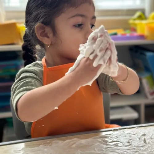 Boy picks paper out of different colored liquids