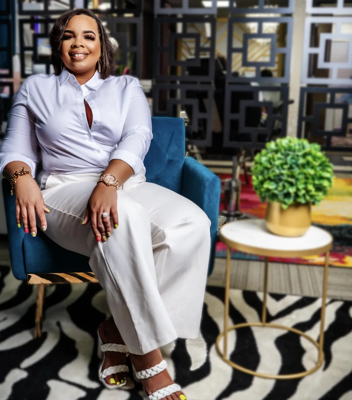 Ash, founder of Enhanced by Ash, in a modern studio, smiling confidently