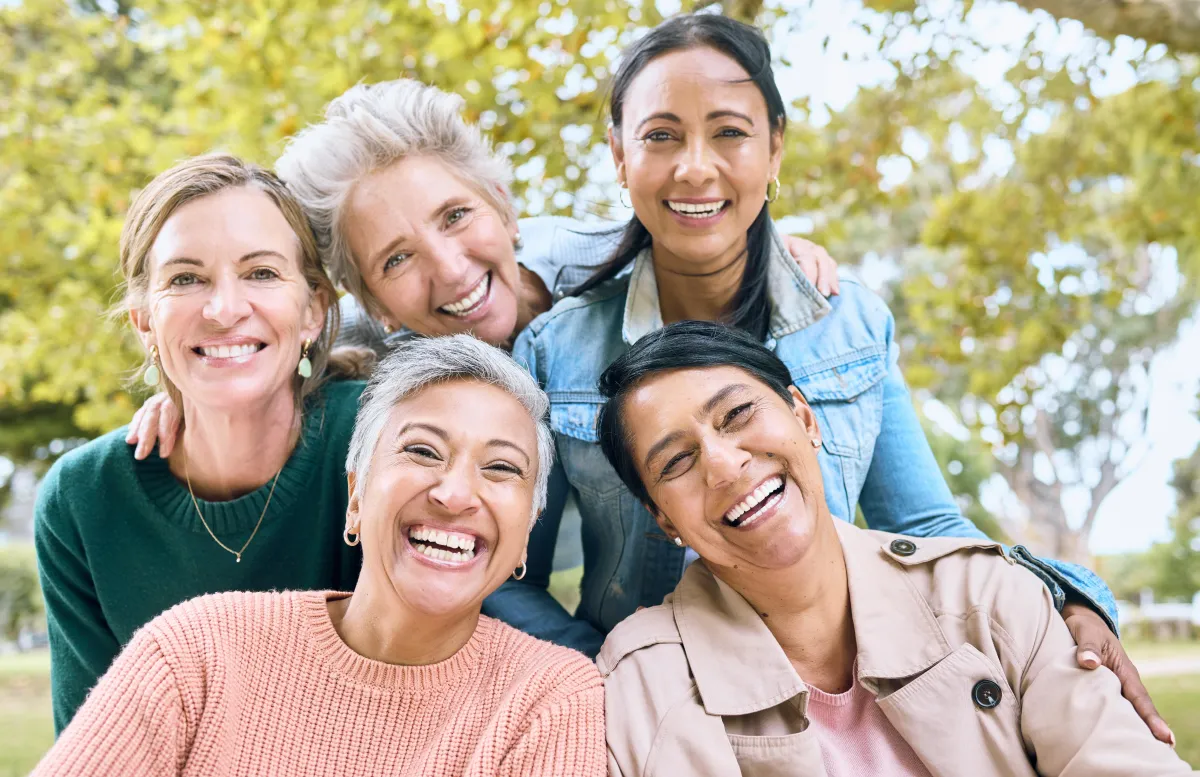 Diverse group of happy middle-aged women outdoors — representing community and women’s health and wellness.