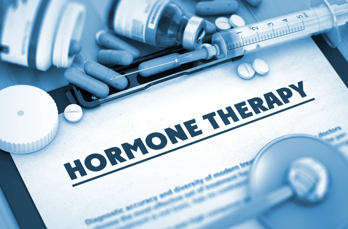 Hormone therapy concept with syringe, capsules, and prescription form — affordable access to private hormone medications from UK pharmacies.
