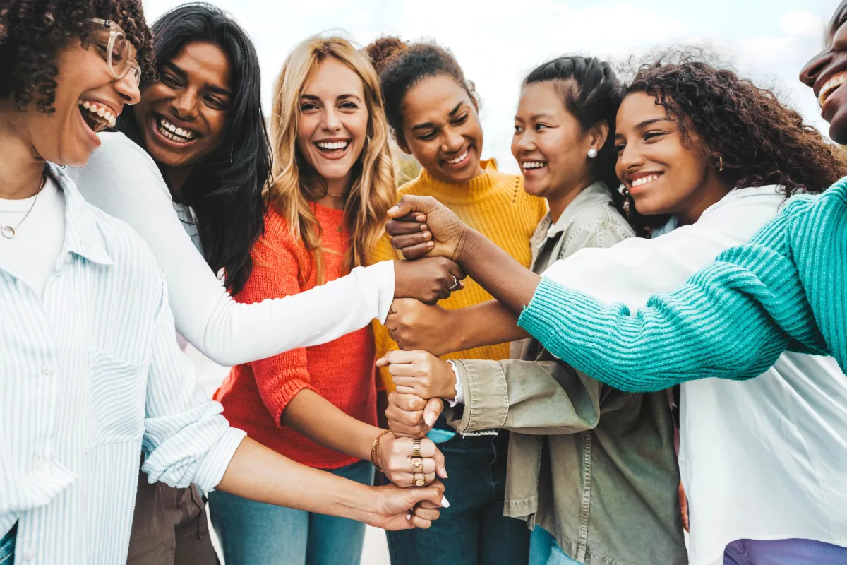Diverse group of smiling women standing together, symbolising support and empowerment through access to affordable women’s health medication in the UK