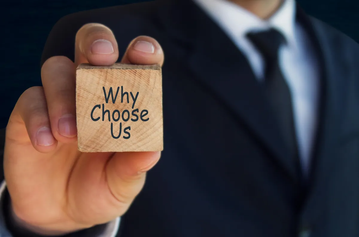 Businessman holding a wooden block with 'Why Choose Us' text, highlighting reasons to trust our pharmacy services