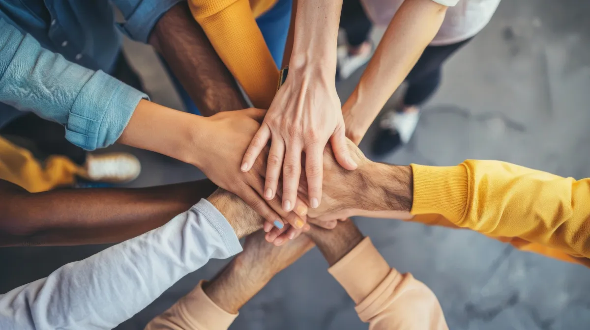 Diverse team of professionals uniting hands to represent collaboration and trust in healthcare services
