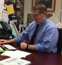 Portrait of a smiling Easton teacher outdoors, photorealistic and approachable.