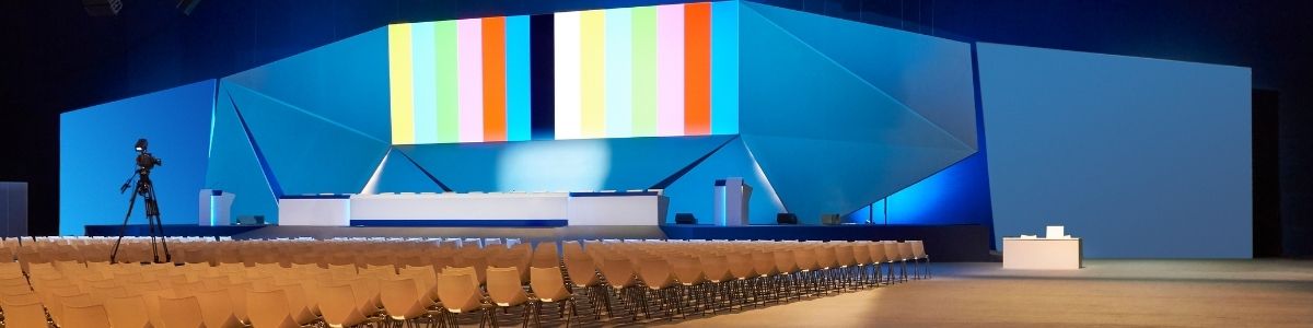 high-end corporate event production stage setup with large LED screens and vibrant stage lighting.