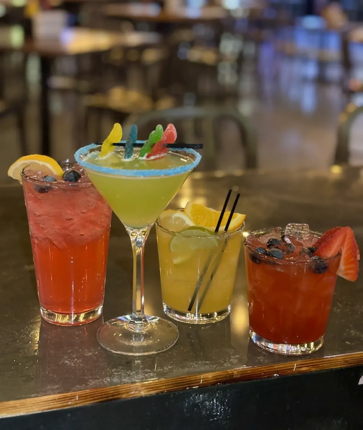 A display of several colorful cocktails in various glasses.