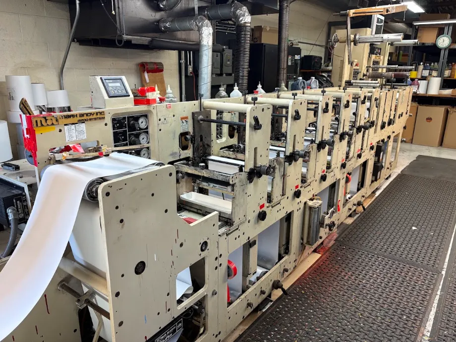 Close-up of flexographic label production equipment and finished label roll (placeholder manufacturing photography)