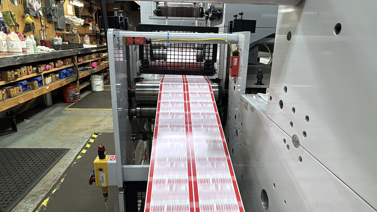 Precision label press finishing detail showing web material and rollers