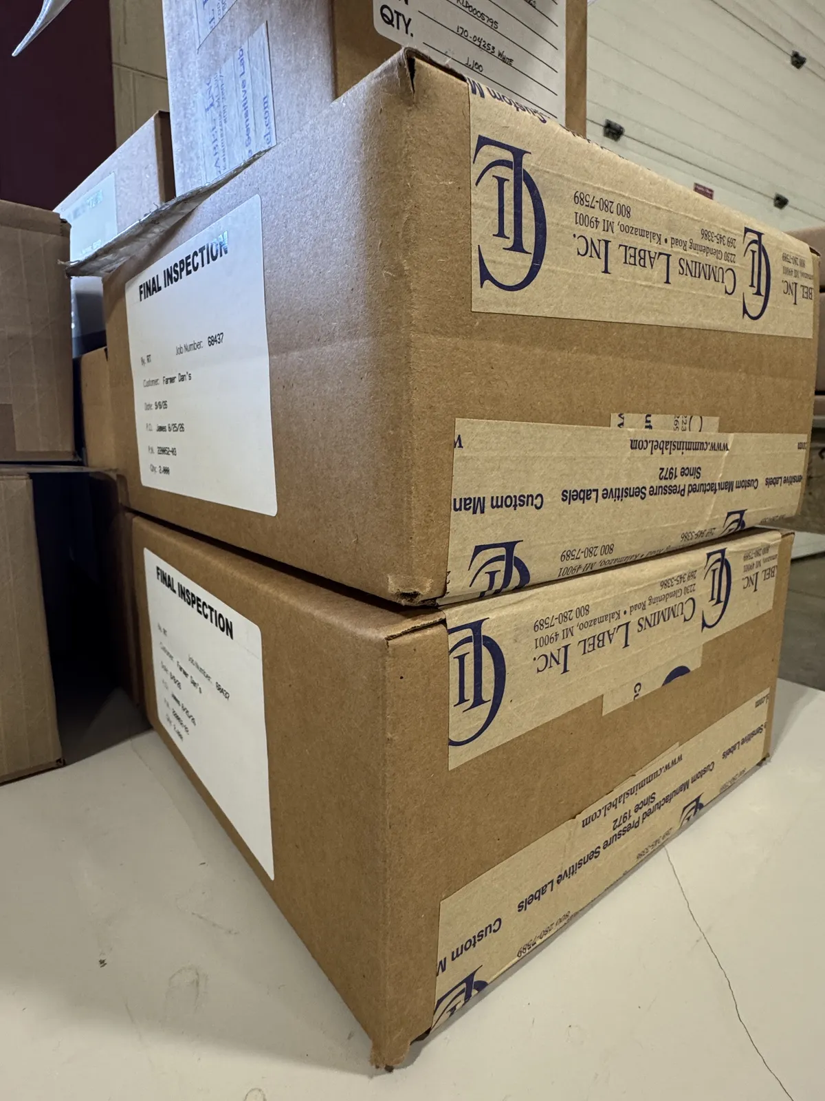 Finished rolls of printed pharmaceutical and medical product labels arranged neatly on an industrial staging table