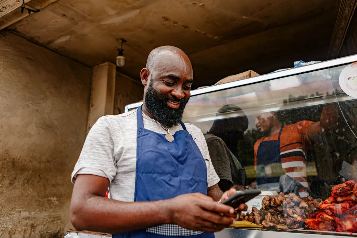 Small business owner checking a customer message on his phone