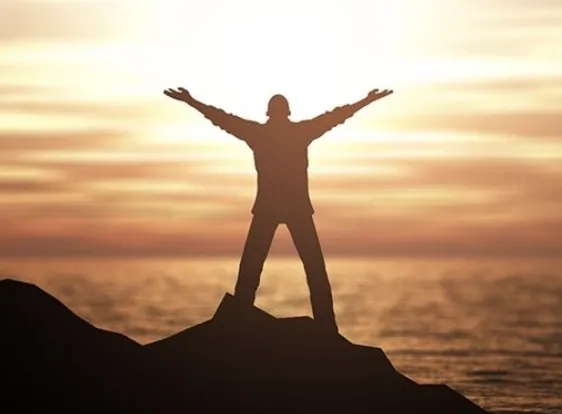 Bob Frissell seated in a warm study, medium shot 1:1 portrait format, natural window light, books and plants blurred in background, relaxed pose, candid photorealistic moment conveying approachability and lived experience.