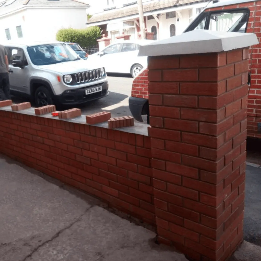 A newly built front garden red brick wall with pillars