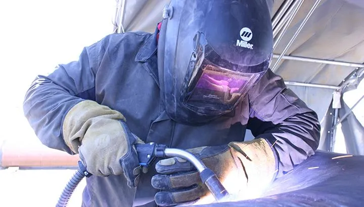 Welder in action, performing precise welding work on-site with professional equipment, representing Walker Mobile Welding's mobile welding services in Tucson, AZ.