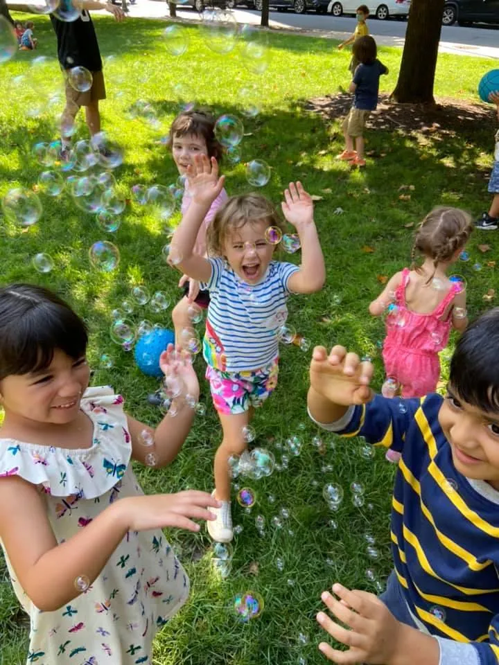 picture of Ko12 Kids on 12th students playing outdoor with bubbles.