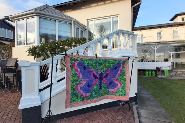 Colourful moth patchwork quilt displayed outside a retreat venue on Wirral Peninsula