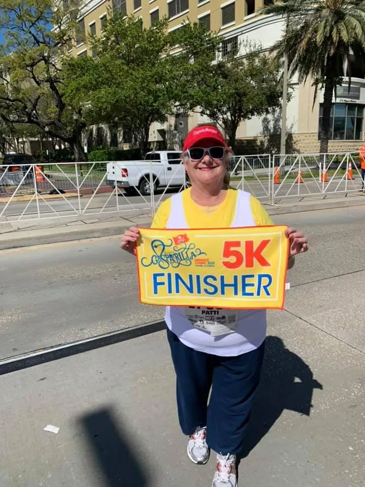 Photo of Patti with 5K banner