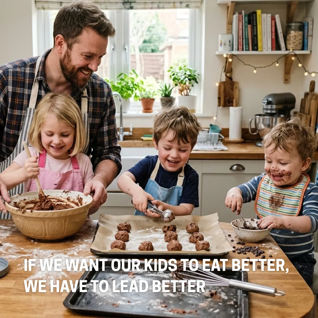 Father and children making homemade protein cookies together in a bright family kitchen.
