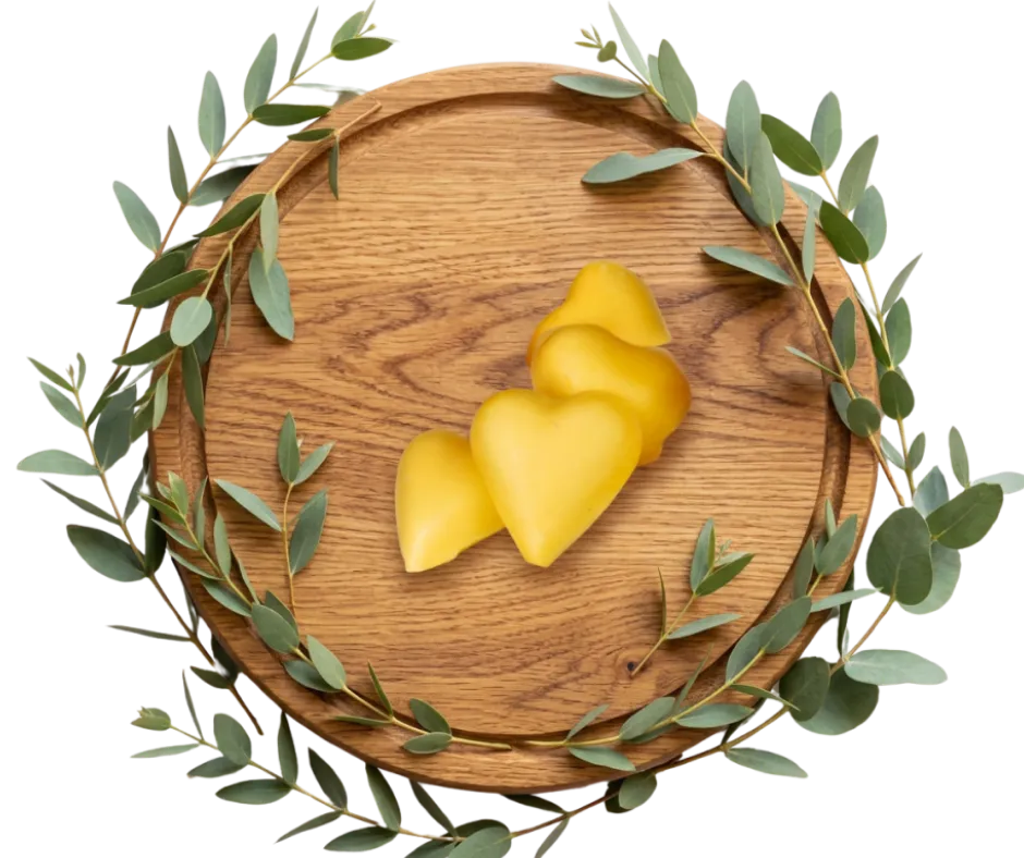 A cinematic full-bleed shot of raw natural ingredients like shea butter, dried botanicals, and high-quality oils arranged elegantly on a warm neutral surface