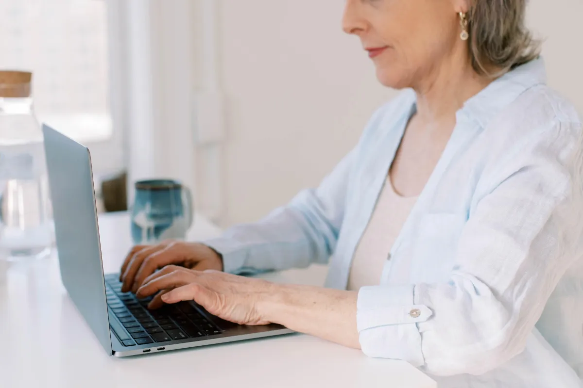 Mature woman typing on laptop