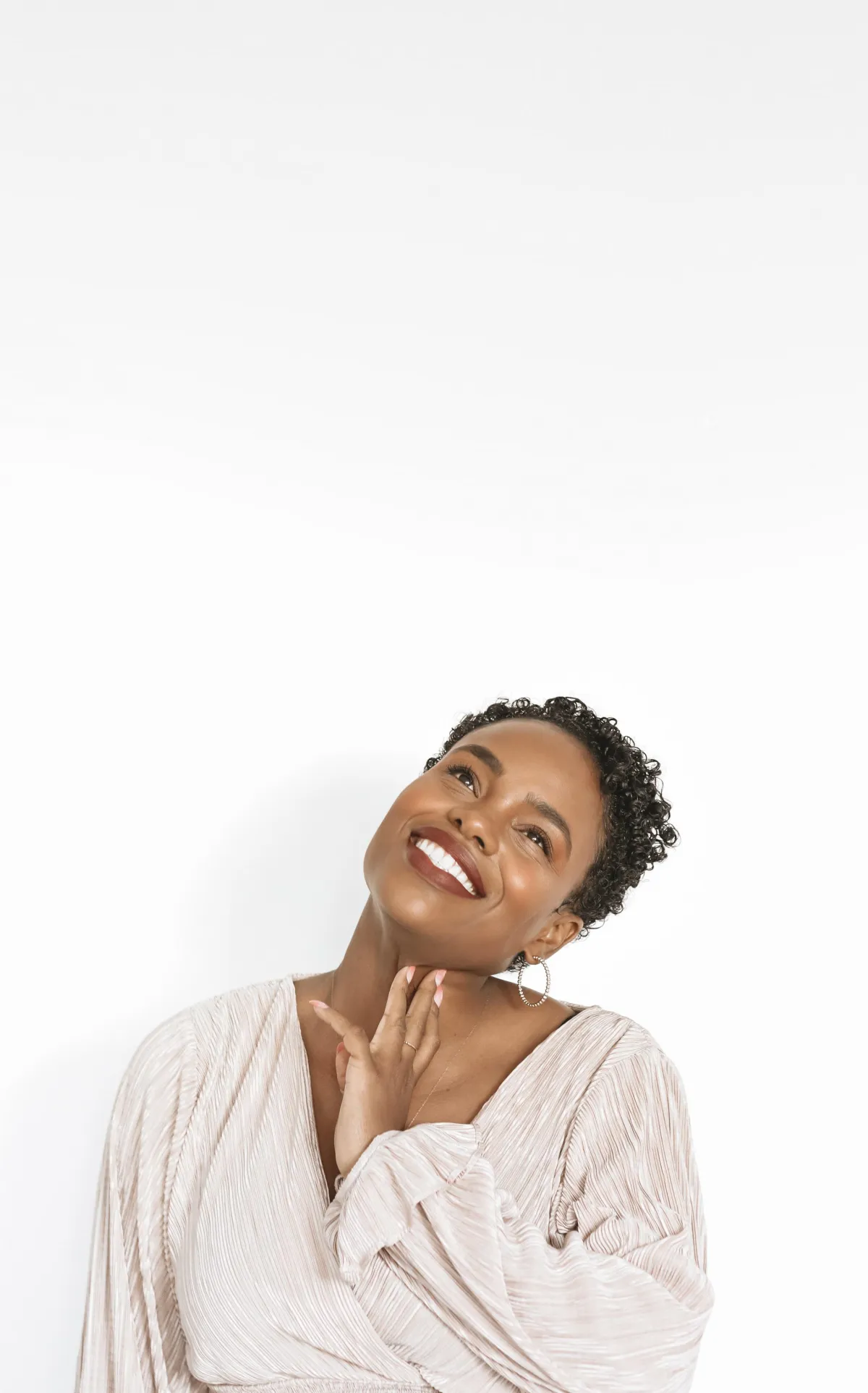 Woman brightly smiling looking up as if imagining.
